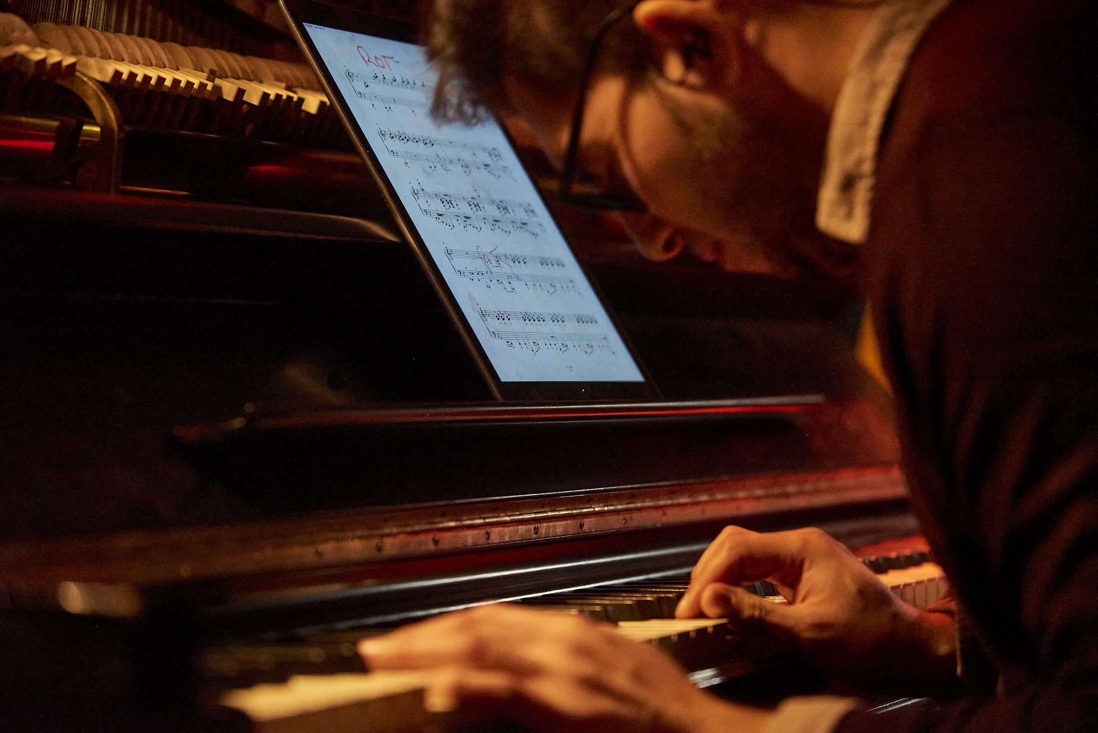 At the piano, working from a score